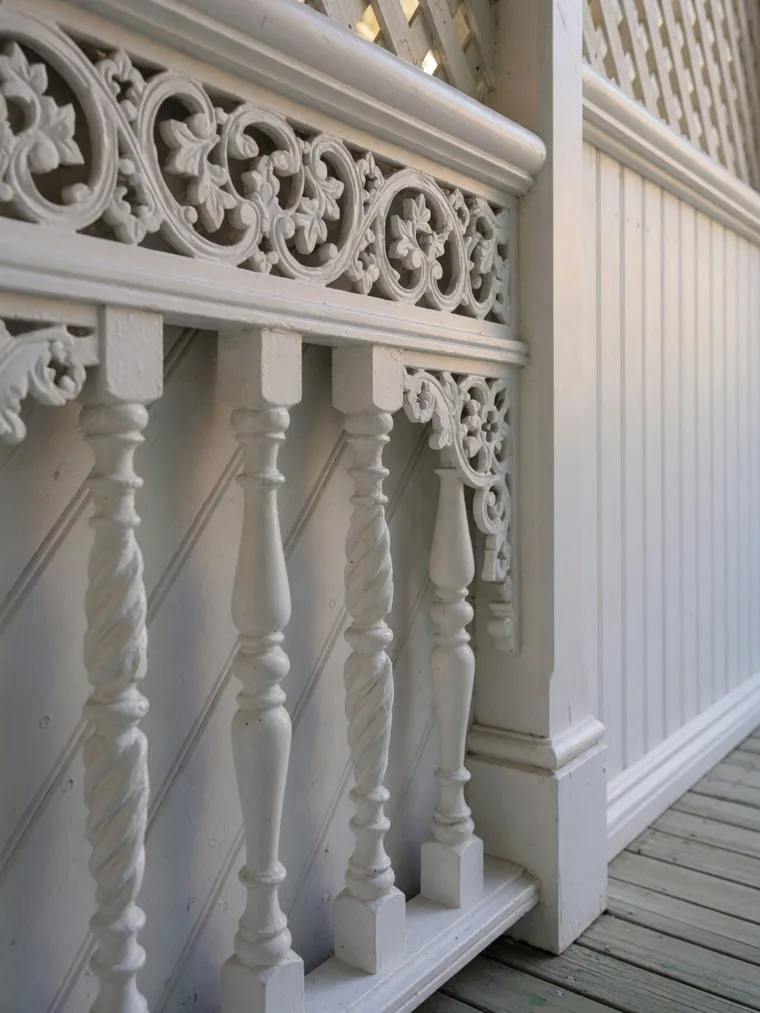 Ornate white timber fretwork and turned balustrade on a restored inner-Brisbane Queenslander verandah